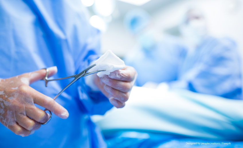 Chirurgien coupant le coton des ciseaux dans la salle d'opération